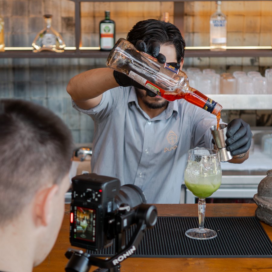 Câmera em gimbal gravando um bartender servindo um drinque